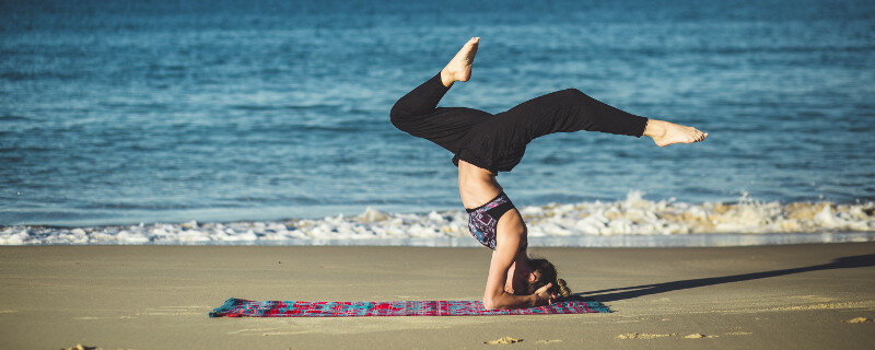 Authentische Streitgespräche durch die richtige Haltung - Frau auf Yogamatte am Strand