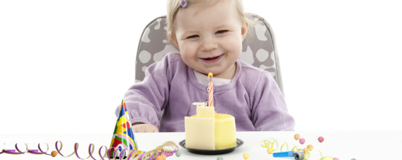 Kleinkind freut sich über erste Kerze auf dem Geburtstagskuchen