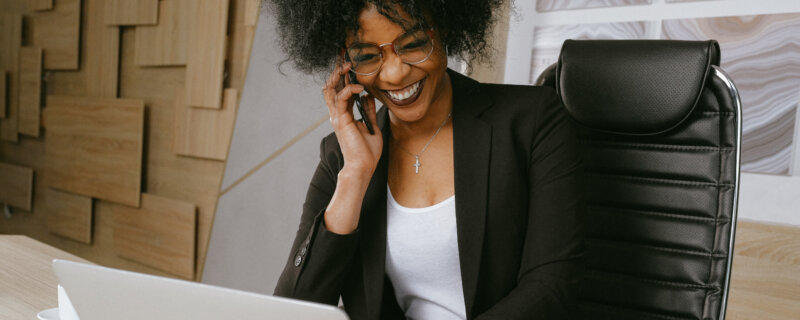 Hot to get Headhunted - Fröhliche Frau vor Laptop